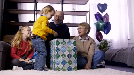 Niño-niño-abrir-la-caja-de-regalo-grande-en-casa