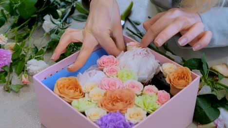 Professional-florist-making-gift-box-with-flowers-at-flower-store