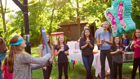 Amigos-ver-a-una-joven-golpeando-una-piñata-por-su-cumpleaños