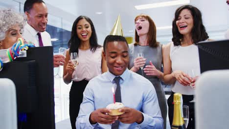 Colleagues-gather-at-a-mans-desk-to-celebrate-his-birthday