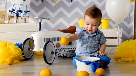 The-child-is-playing-with-bright-yellow-lemons-on-the-floor.