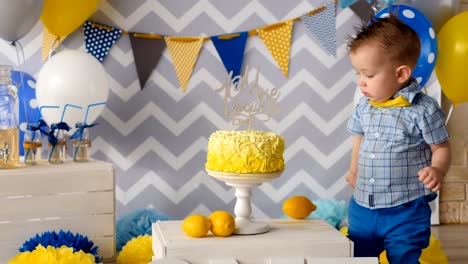 The-boy-is-touching-his-birthday-cake-with-a-finger.