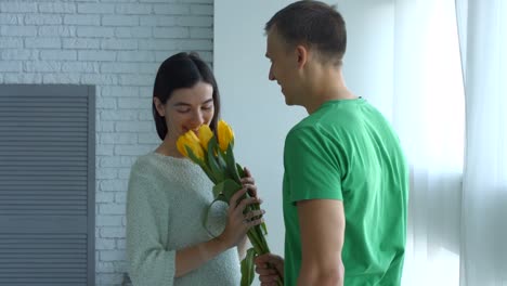 Excited-woman-surprised-by-bunch-of-flowers-from-man