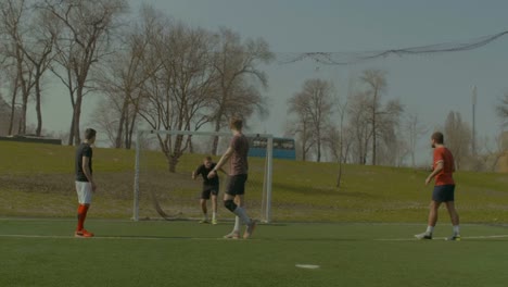 Positivo-adolescentes-jugando-al-fútbol-en-el-campo-de-los-deportes