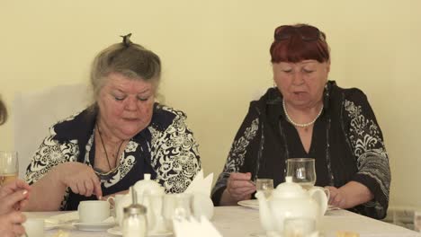 Senior-citizens-at-festive-dinner-eating-cake