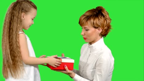 Pretty-caucasian-woman-getting-chrismas-gift-from-her-daughter-on-a-Green-Screen,-Chroma-Key