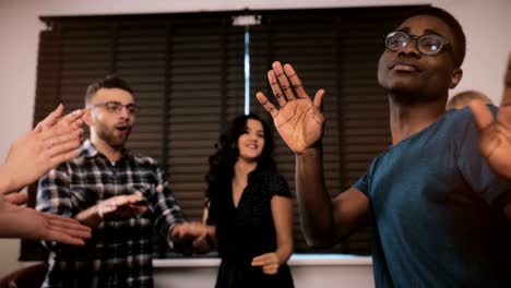 Excited-African-American-guy-dancing-with-multiethnic-friends-at-casual-birthday-party-at-home-slow-motion-panning-shot