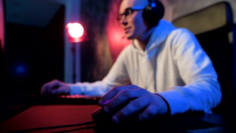 Close-up-addiction-guy-with-manly-hands-playing-video-game-on-computer-screen-with-fingers-on-keyboard.-Selective-focus-on-a-hand-with-mouse