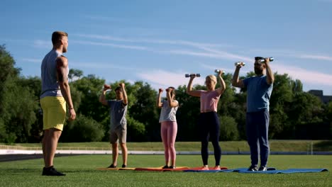 Man-training-family-with-kids-on-field