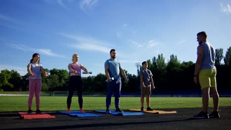 Man-training-family-with-kids-on-field