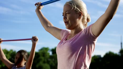 Mujer-con-niños-haciendo-ejercicio-en-el-campo-de-deportes