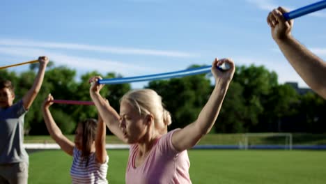 Mujer-con-niños-haciendo-ejercicio-en-el-campo-de-deportes