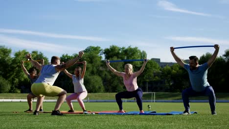 Familie-mit-personal-Trainer-arbeiten-auf-Feld