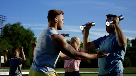 Man-training-family-with-kids-on-field