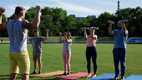 Family-training-with-personal-coach-on-field