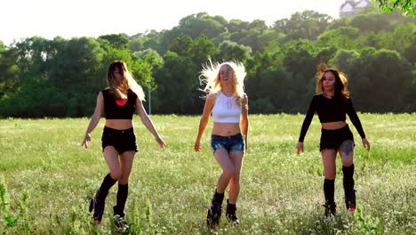 Group-training-kangoo.-Three-girls-at-sunset-in-the-Park-doing-fitness