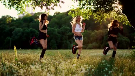 Group-training-kangoo.-Three-girls-at-sunset-perform-dynamic-squats-aimed-at-slimming-and-strengthening-the-muscles-of-the-thighs
