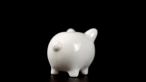 The-concept-of-charity-during-the-movember,-someone-puts-a-coin-in-piggy-bank.