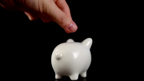 The-concept-of-charity-during-the-movember,-someone-puts-a-coin-in-piggy-bank.