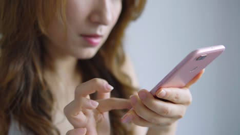 Asiática-mujer-con-celular-en-la-sala-de-estar