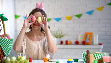 Fröhliche-Frau,-die-Ostereier-zu-Augen,-Spaß-haben-und-genießen-Sie-helle-Fest-setzen