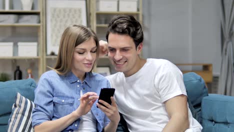 Feliz-pareja-joven/esposos-Internet-navegación-en-Smartphone-en-el-país