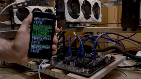 Concept-of-cryptocurrency-mining-on-smartphone-with-trader-holding-in-his-hand-a-cellphone-with-crypto-code-app-mobile-displaying