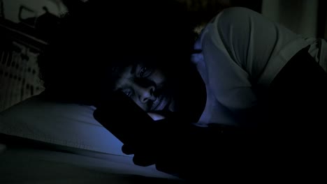 Close-Up-of-African-Man-Using-Phone-in-Bed