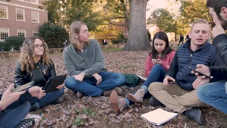 Grupo-de-estudiantes-universitarios-todos-usando-sus-dispositivos-móviles-y-teléfonos-inteligentes