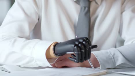 Businessman-Writing-Note-with-Prosthetic-Hand