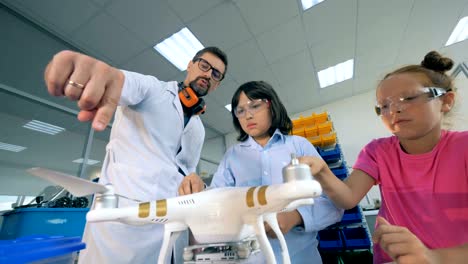 Kinder-erkunden-Drohne-mit-einem-Lehrer-in-einer-Technikklasse.