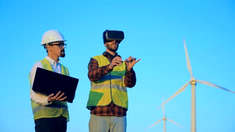 Engineers-using-360-VR-glasses-near-windmills.-Innovative-engineering-concept.