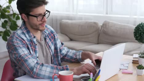 Man-working-on-laptop-and-talking-on-mobile-phone