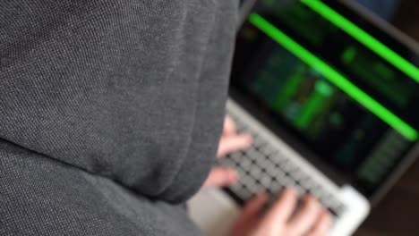 Anónimo-Hooded-hacker-programación-en-la-consola-de-ordenador-rompiendo-contraseña