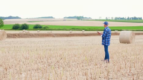 Moderne-Landwirtschaft.-Die-Liebe-zur-Landwirtschaft.-Landwirt-mit-digitalem-Tablet-bei-der-Prüfung-von-Bauernhof