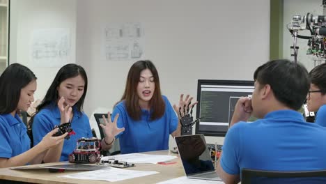 Young-electronics-engineer-team-collaborating-on-construction-of-robot-in-the-workshop.-Team-engineer-start-up-for-robot-project-together.-People-with-technology-or-innovation-concept.