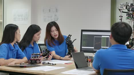 Young-electronics-engineer-team-collaborating-on-construction-of-robot-in-the-workshop.-Team-engineer-start-up-for-robot-project-together.-People-with-technology-or-innovation-concept.