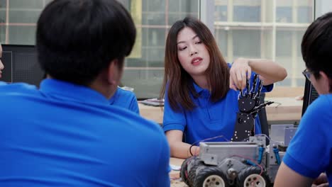 Female-engineer-having-conversation-to-robot-project-with-her-team-at-lab.-Technology-and-innovation-concept.