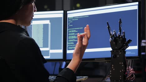 Asian-testing-cyborg-hand-at-control-room.-Female-doing-her-robot-project-she-testing-sensor-signal.-Technology-and-innovation-concept.