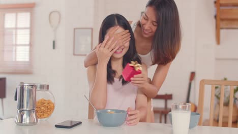 Asian-Lesbian-couple-giving-present-surprise-on-her-birthday-or-Valentines-day-while-having-breakfast-in-kitchen-in-the-morning.