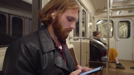 Hombre-usando-Smartphone-mientras-está-sentado-en-el-vagón-del-metro