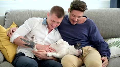 Gay-couple-relaxing-on-couch-with-dog.-Relaxing-the-dog.