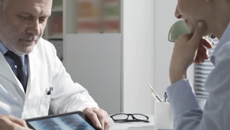 Doctor-showing-a-radiograph-to-a-patient-using-a-tablet