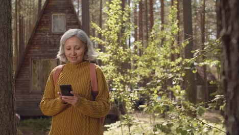 Wanderer-mit-Handy-in-der-Nähe-von-Wooden-Cabin