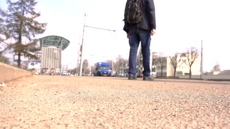 Viajero-turístico-masculino-esperando-el-transporte-público-en-una-parada-de-autobús-en-la-ciudad,-viaje