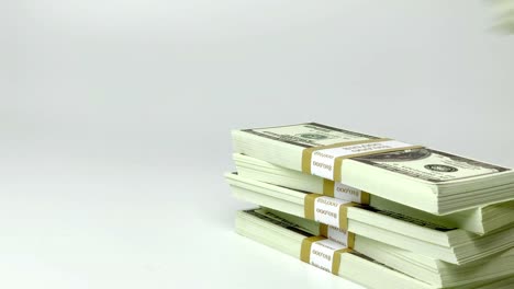 Investing-funds,-economics-transaction-and-wealthy-millionaire-counting-money-conceptual-idea-with-hand-that-stacks-wads-of-100-American-dollar-bills-isolated-on-white-background-with-copy-space