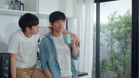 Asian-gay-couple-drinking-coffee,-having-a-great-time-at-home.-Young-handsome-LGBTQ+-men-talking-happy-relax-rest-together-spend-romantic-time-in-modern-kitchen-at-house-in-the-morning-concept.