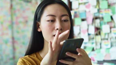 Handheld-Ansicht-der-vietnamesischen-Frau-mit-Handy-im-Café