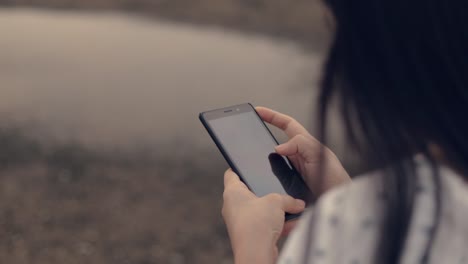 Close-up-asian-teenage-girl-using-smartphone-in-vacation-holiday-typing-messages-sharing-social-media-enjoying-travel-summer.