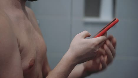 man-with-cell-phone-in-bathroom,-messaging-and-typing